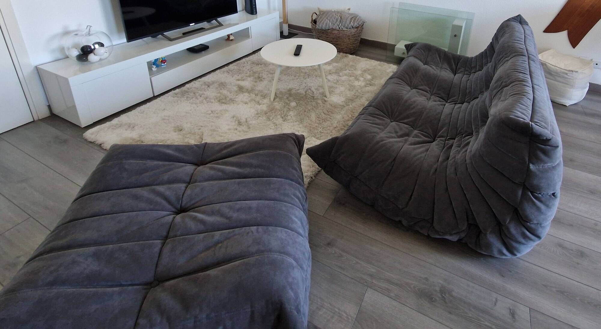 Togo 3-seater sofa by ligne roset with an ottoman.