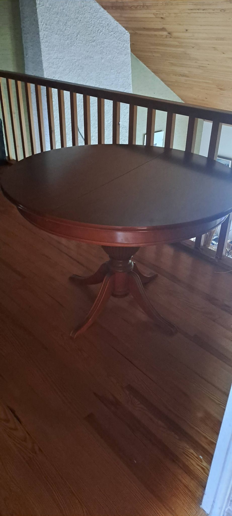 Round solid walnut table with central leg from the 1950s with extensions.