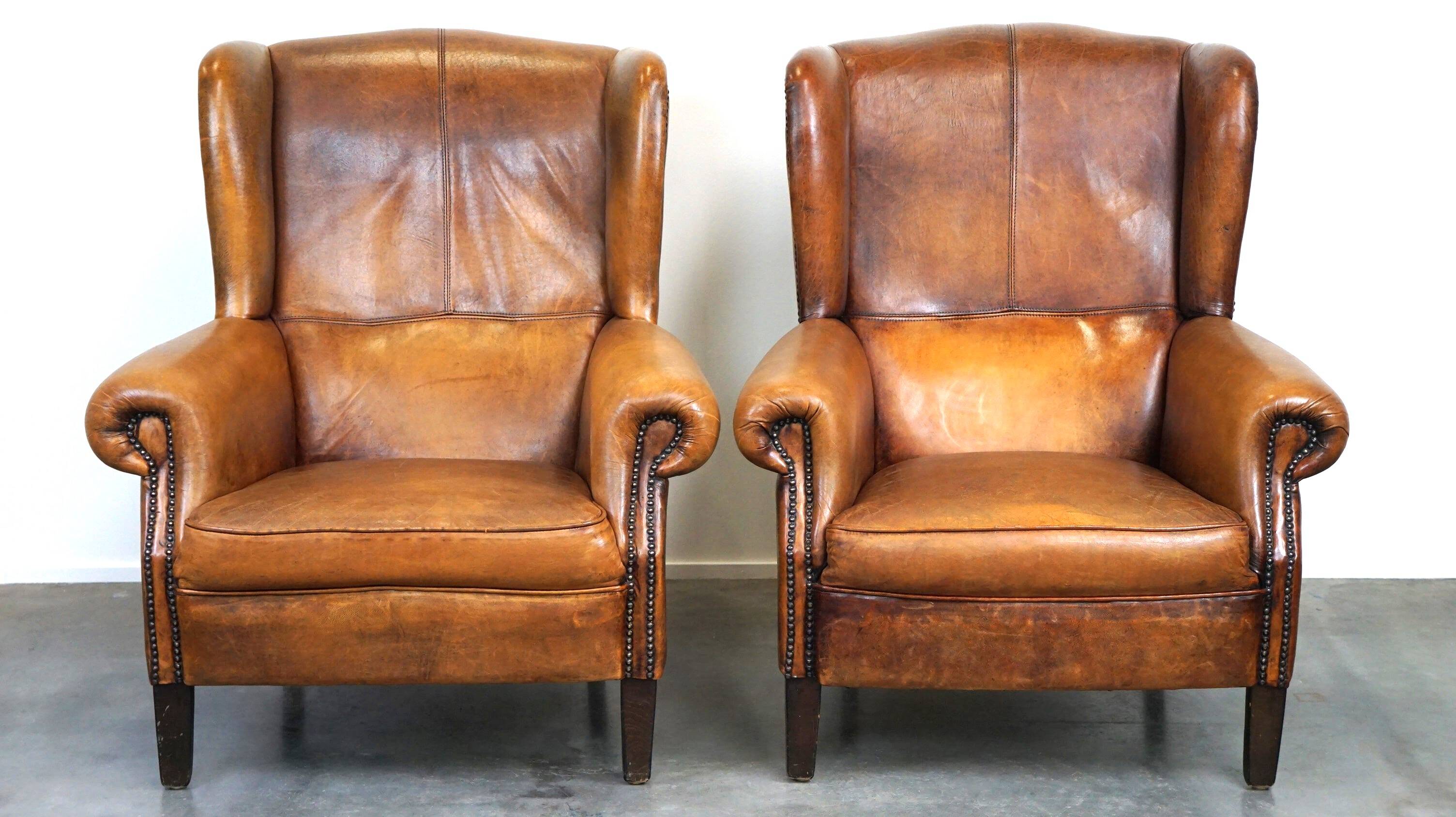 Set of 2 beautiful and correct sheep leather wingback armchairs with fixed seat cushions