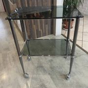 Serving dessert trolley with 2 smoked glass shelves and metal structure.