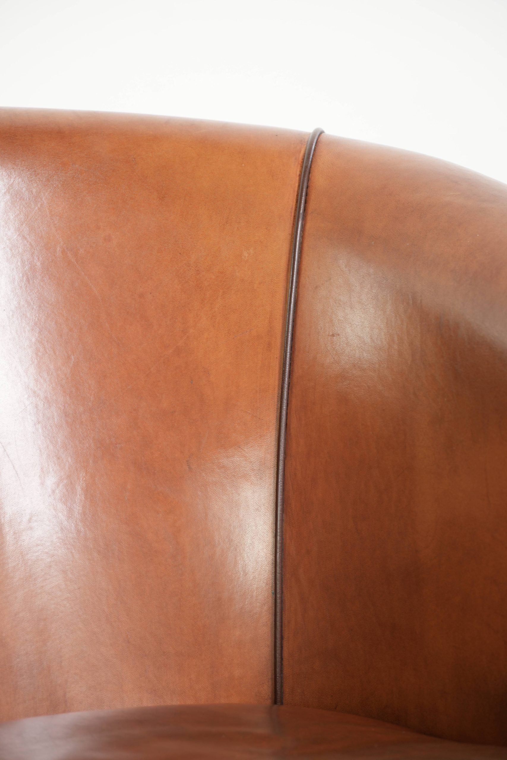 Vintage sheepskin club armchair with a warm colour scheme with black piping