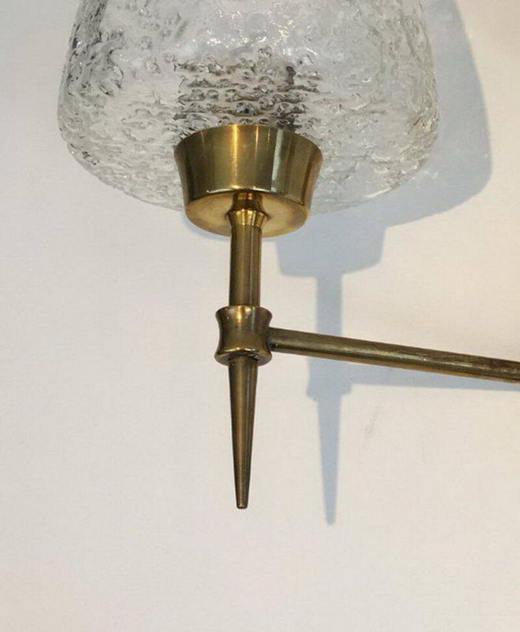 Pair of bronze wall sconces with worked glass reflectors. Stilnovo