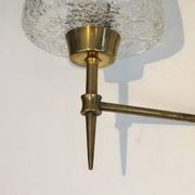 Pair of bronze wall sconces with worked glass reflectors. Stilnovo