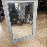 Old mirror with light green contours with mauve shades