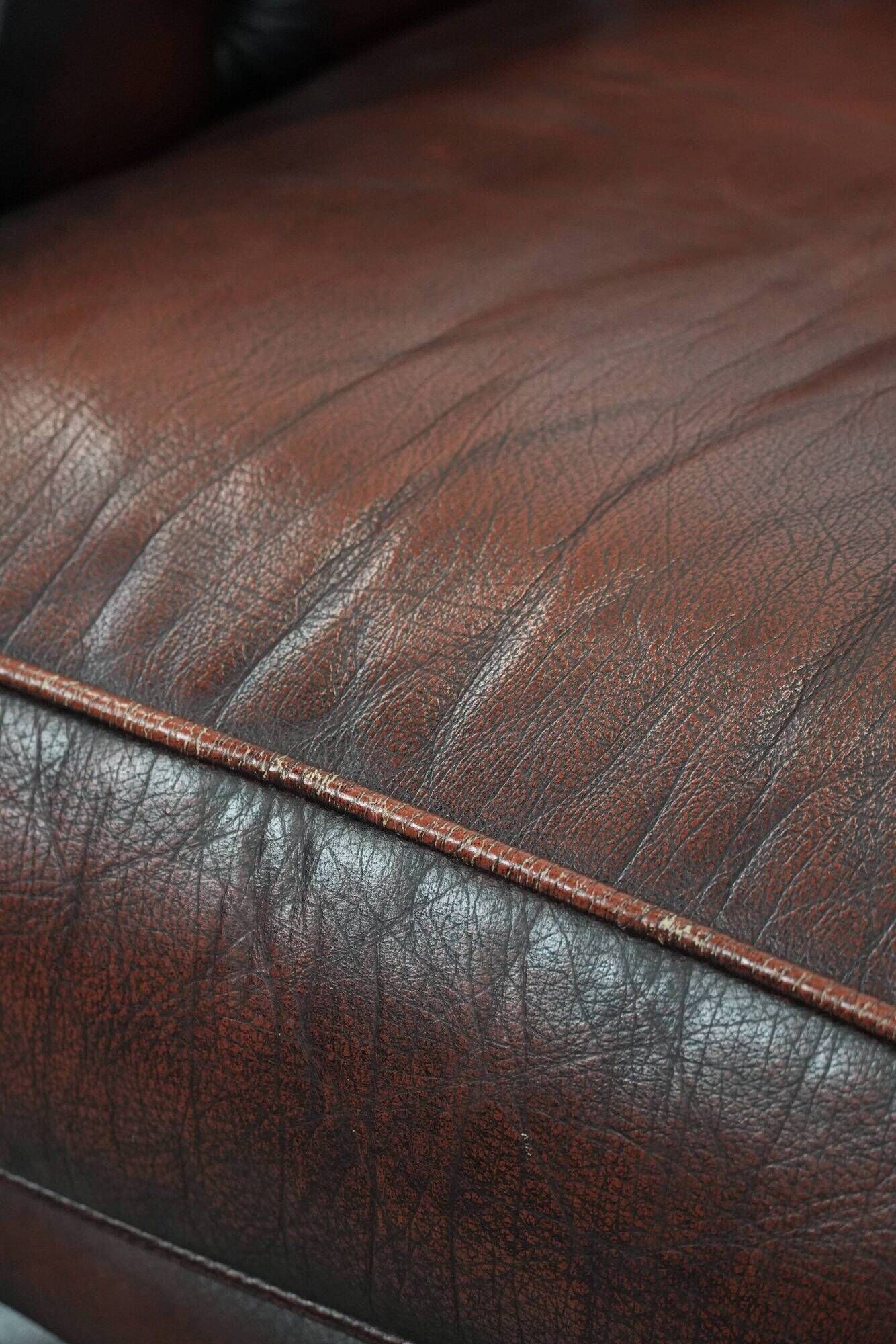 Classic cowhide Chesterfield sofa in English style with red/brown colours