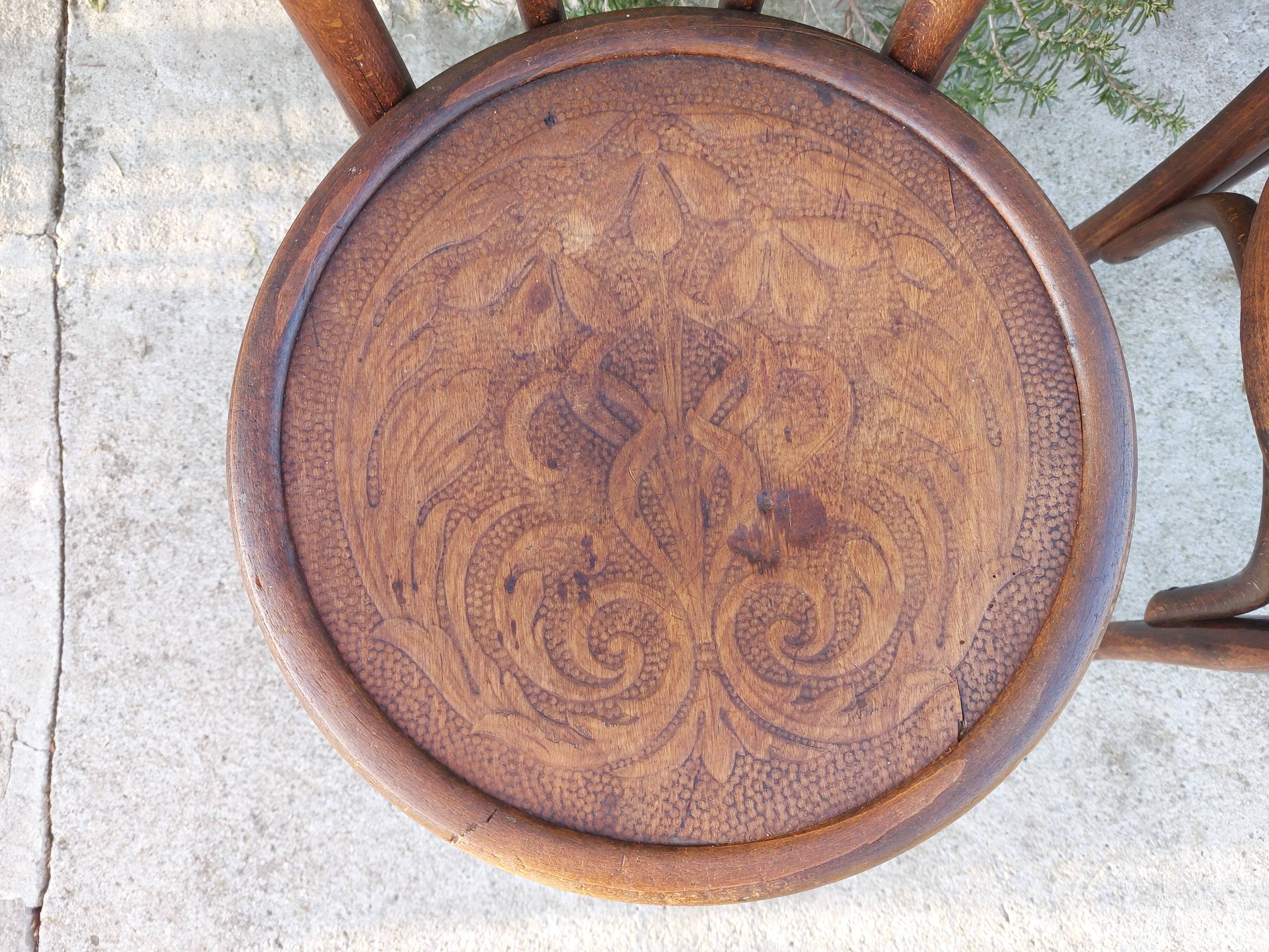 pair of round wooden chairs with a pattern on the seat