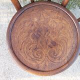 pair of round wooden chairs with a pattern on the seat