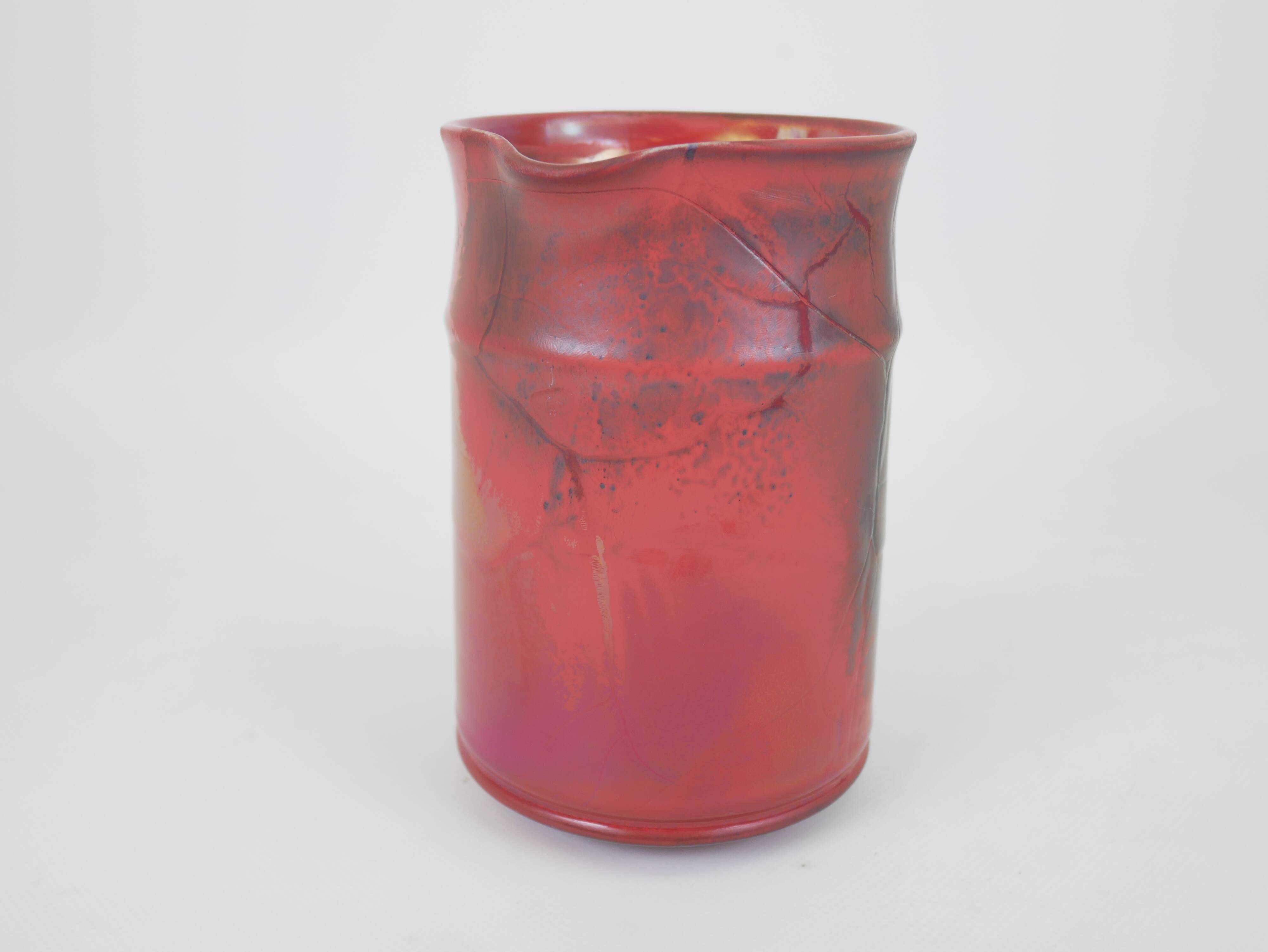 Red glazed ceramic jug with relief