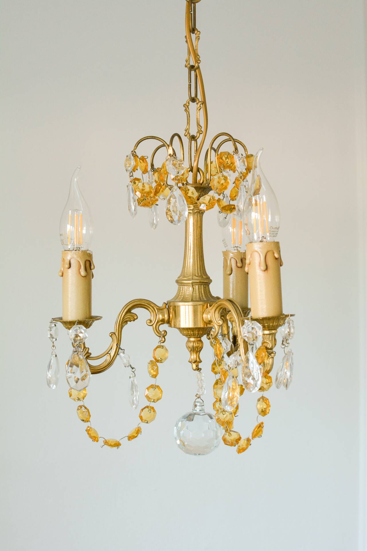 Small vintage brass chandelier with amber crystal pendants.