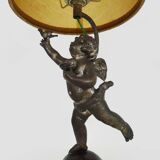 Old table lamp in repel, cherub, angel, cherub, putti with a bird in hand. 1930s