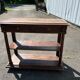 Carved wooden console table with three shelves and drop-leaf flap