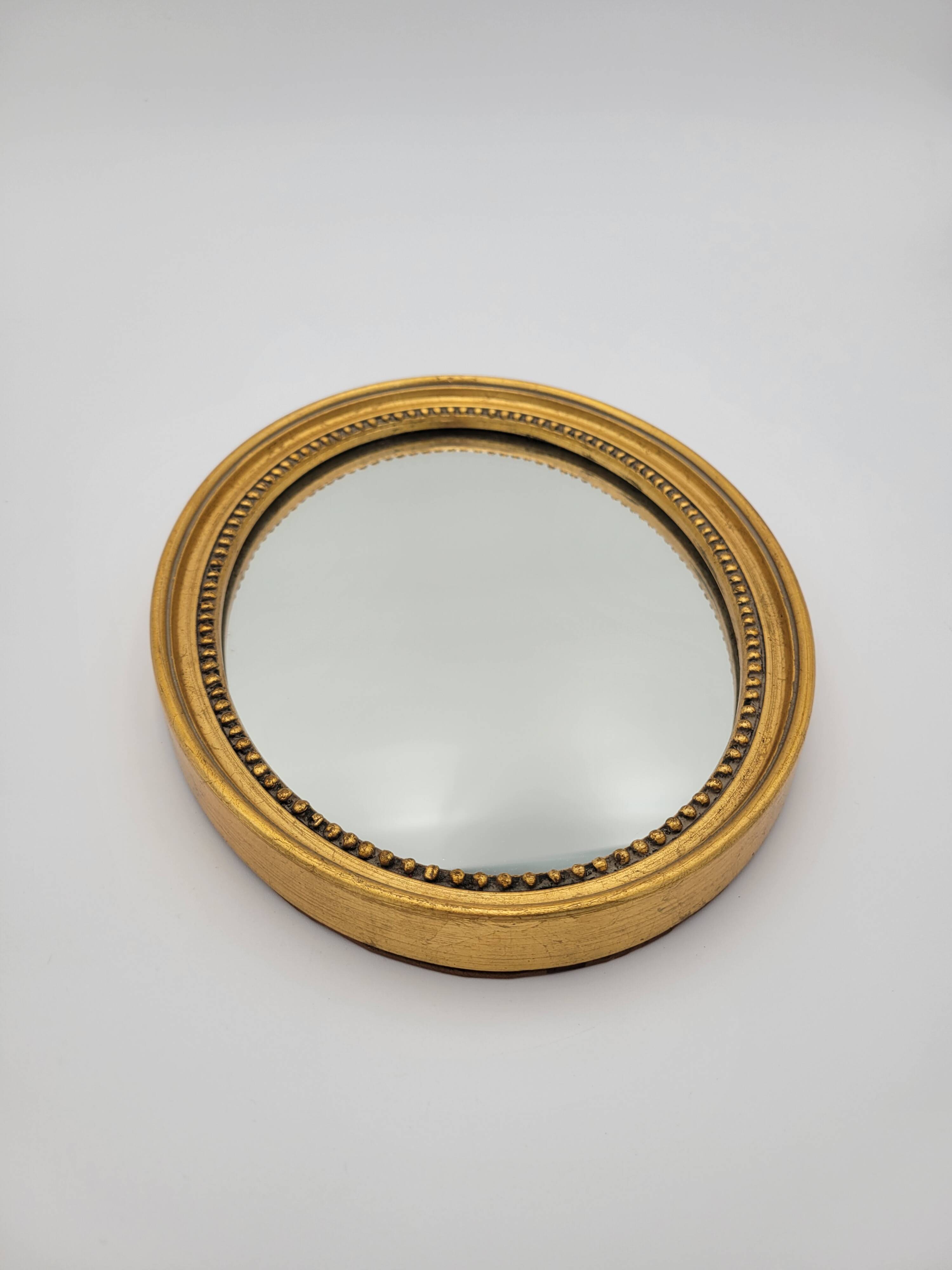 Small old oval mirror in gilded wood
