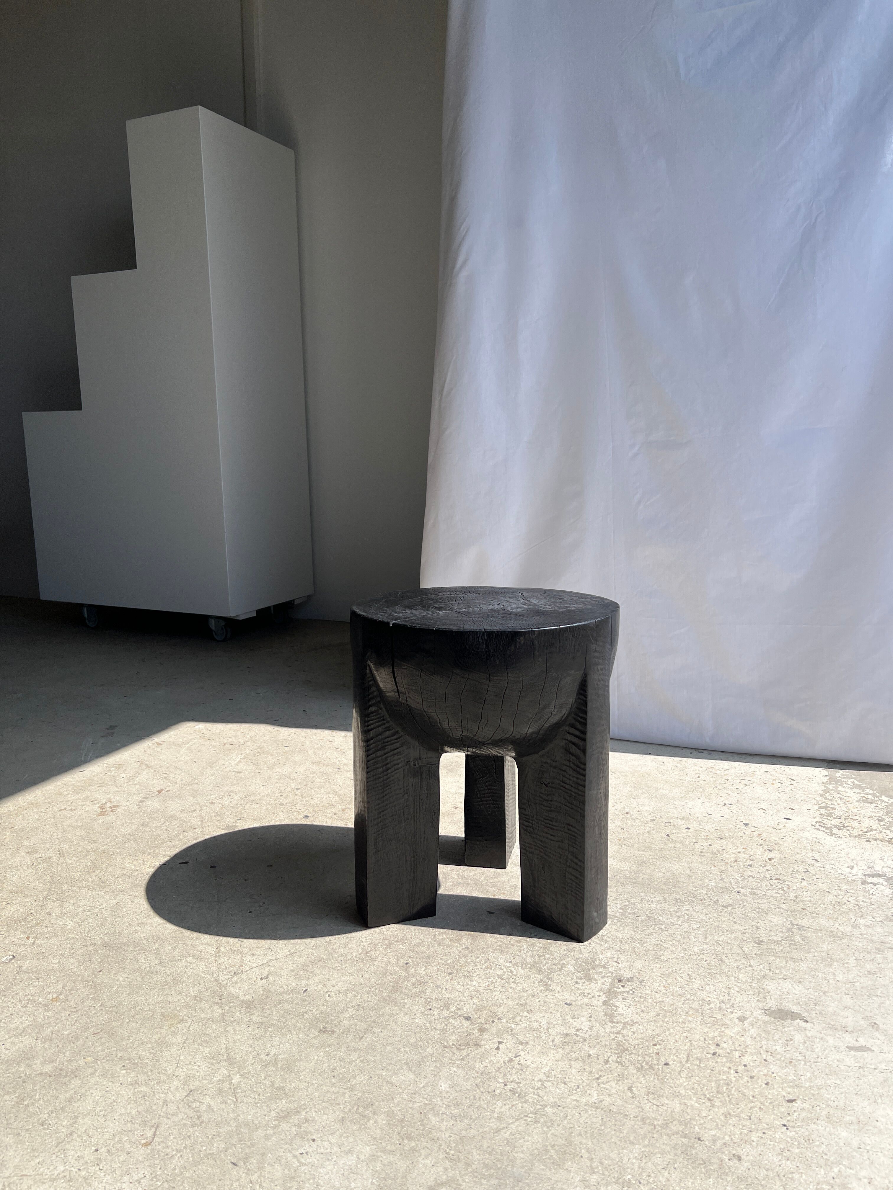 Black mango wood tripod side table with a semi-spherical top, height: 45 cm, diameter: 44 cm.