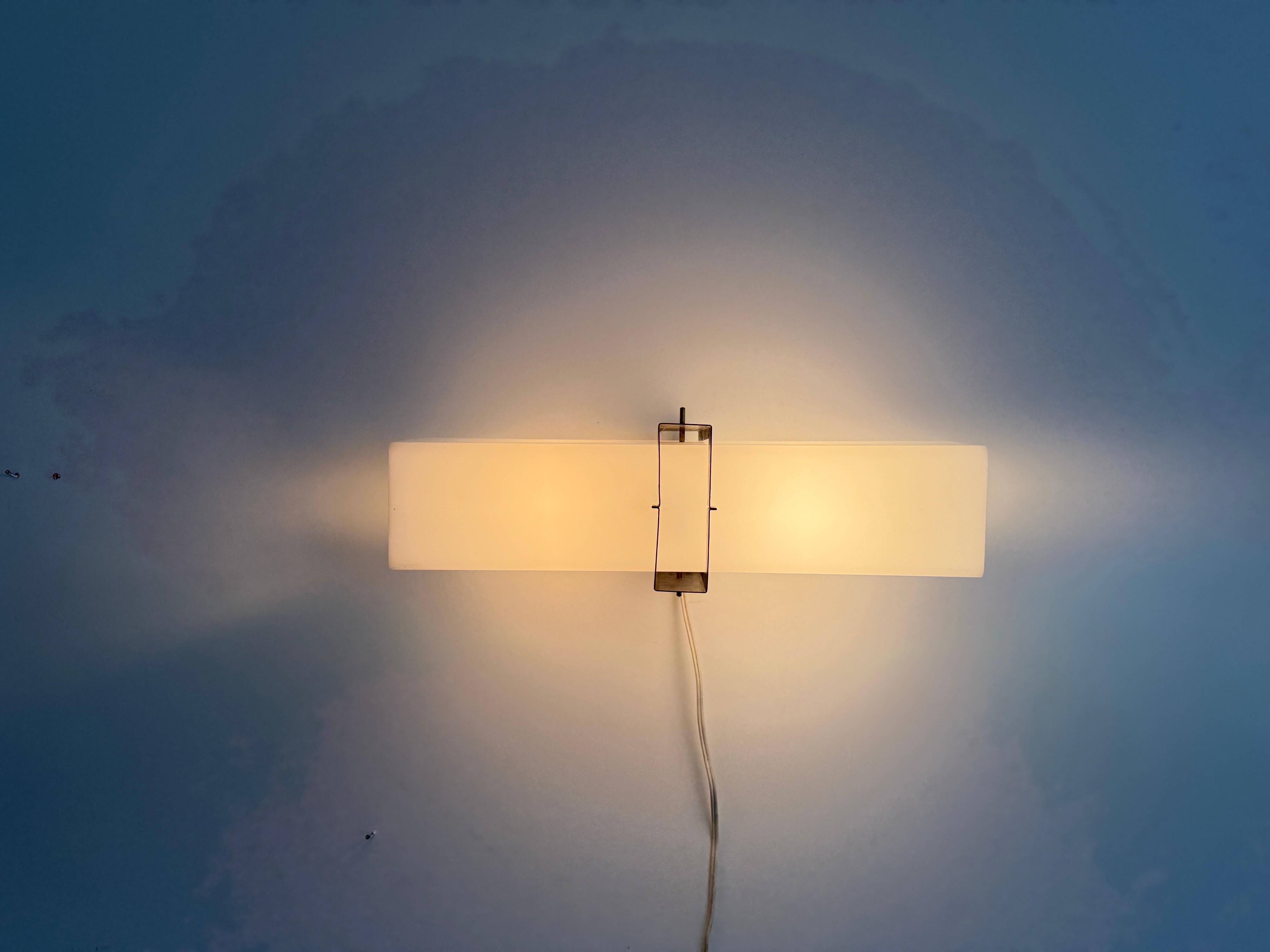 Simple white plexiglass wall light with a black metal frame, 1970s, Germany.