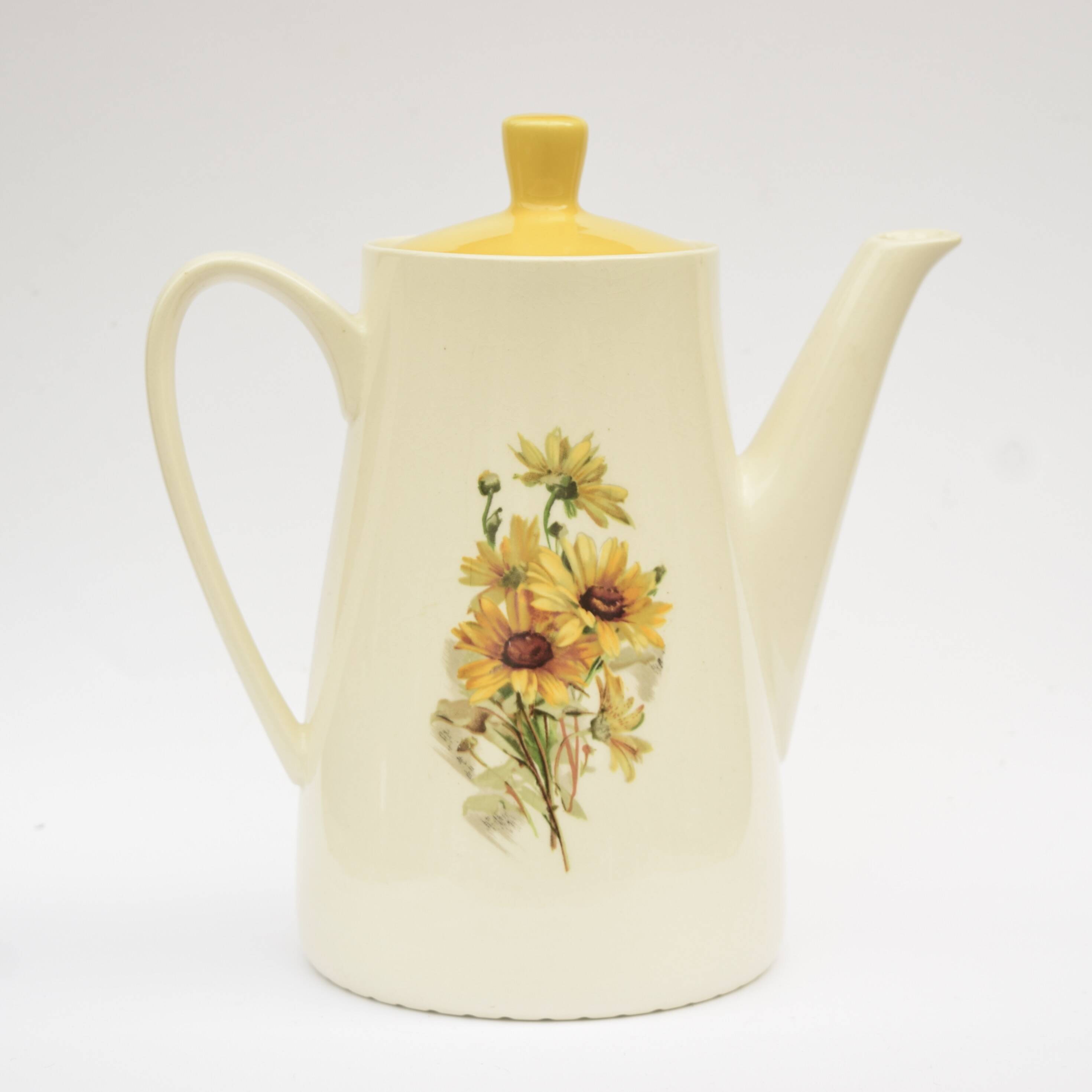 Old glazed ceramic coffee pot decorated with sunflowers