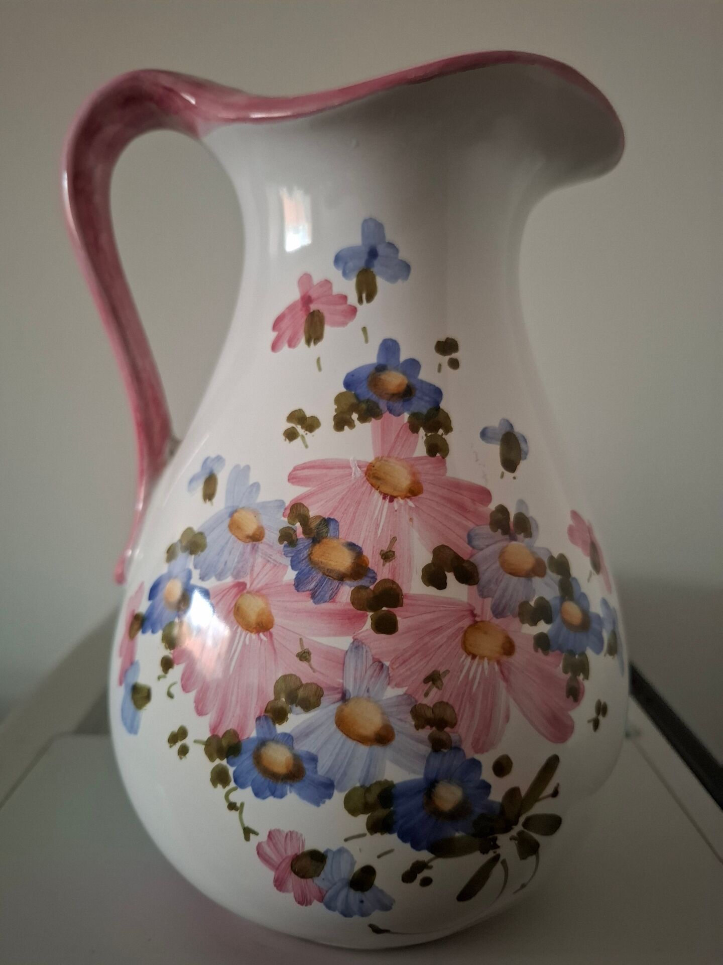 Old ceramic pitcher with floral decoration.