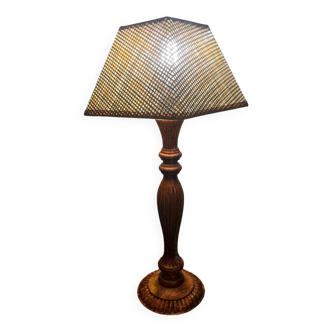 Carved wooden table lamp with lampshade.