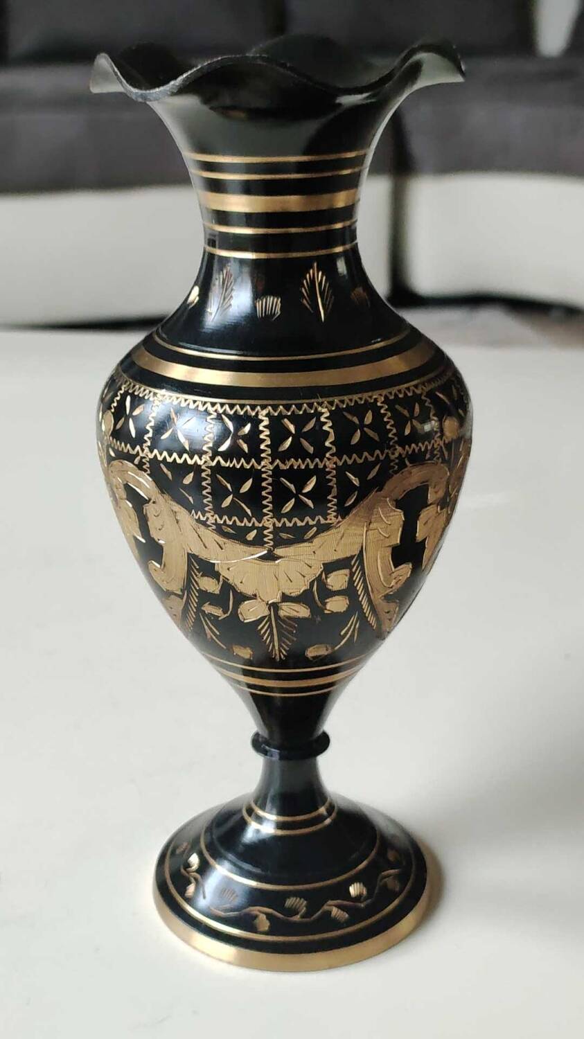 Vintage brass vase with black and gold patina, corolla neck. From India. Mid-20th century. Engraved heart/floral/leafy patterns. High 20 cm