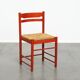 Vintage 1970s red wooden chair with a woven wicker seat