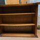 Solid wood bar cabinet with shelves and two stools.