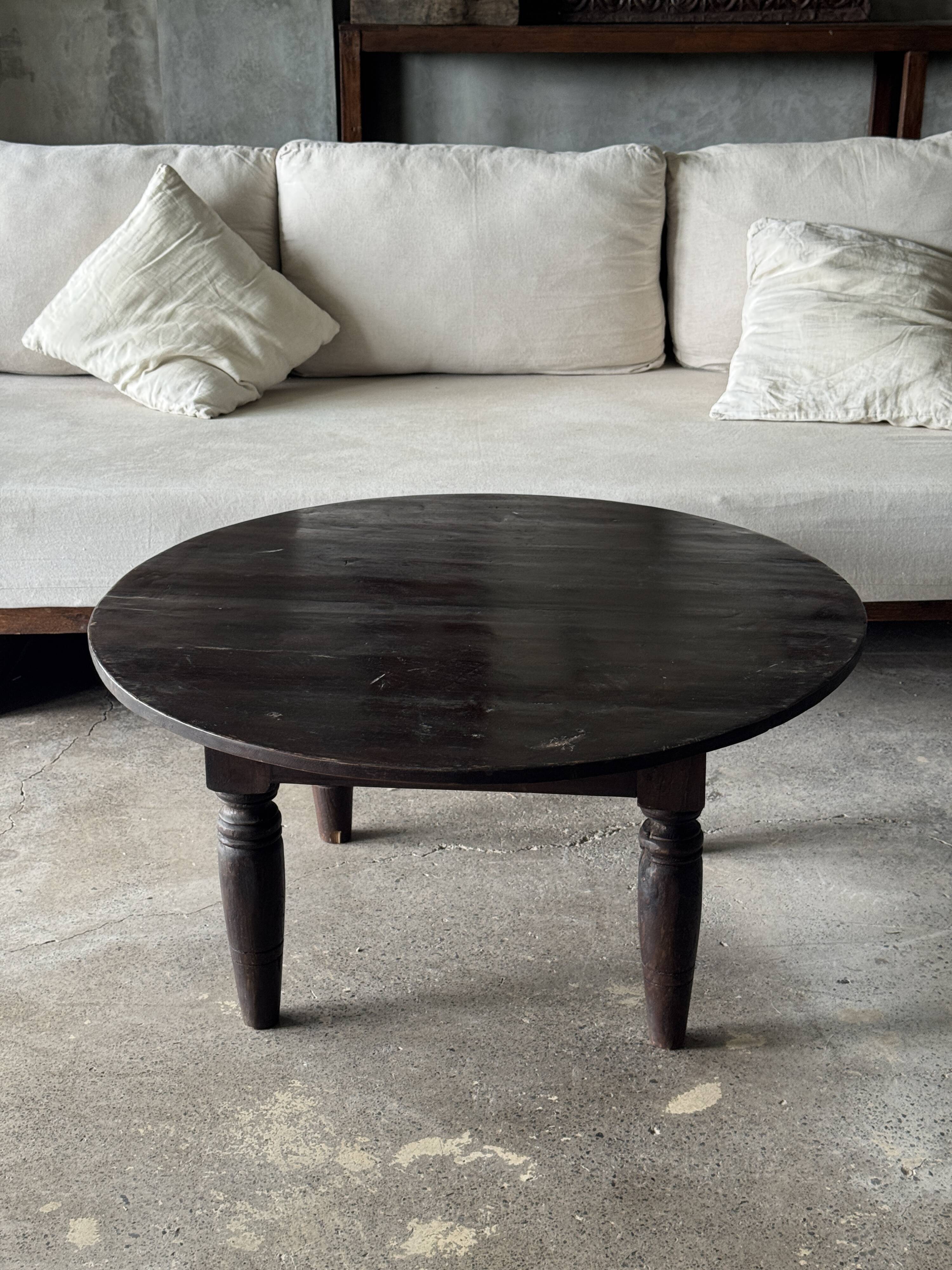Antique round coffee table in Indonesian teak with turned legs.