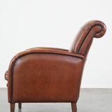 Cognac-colored sheepskin armchair with rounded shapes