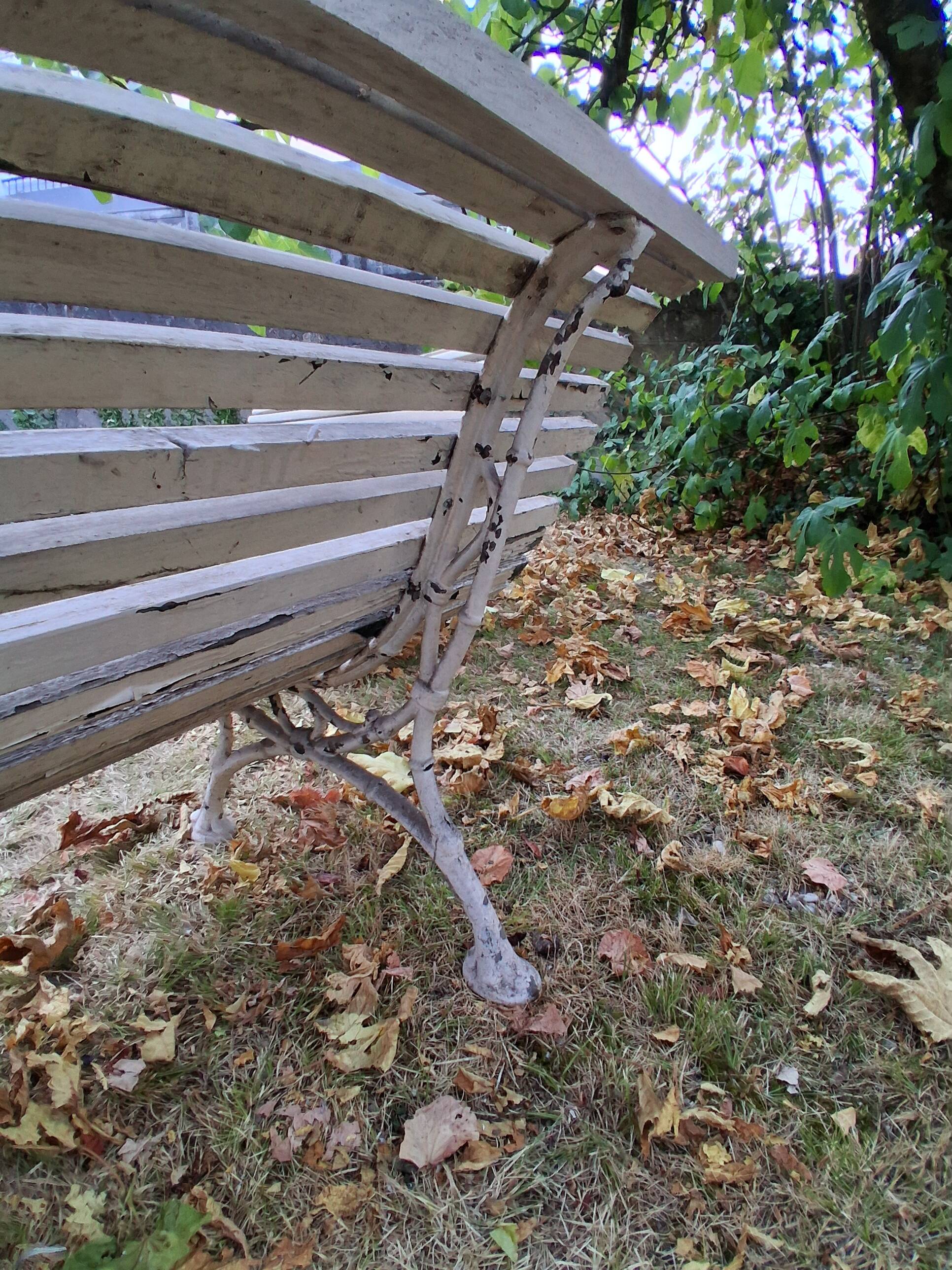 Pair of antique wooden slatted benches with wrought iron legs.