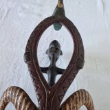 A large Senufo mask made of colored wood, decorated with an anthropomorphic figure