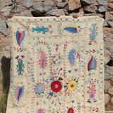 White suzani kilim rug with hand embroidered multi-colored patterns