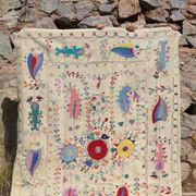 White suzani kilim rug with hand embroidered multi-colored patterns