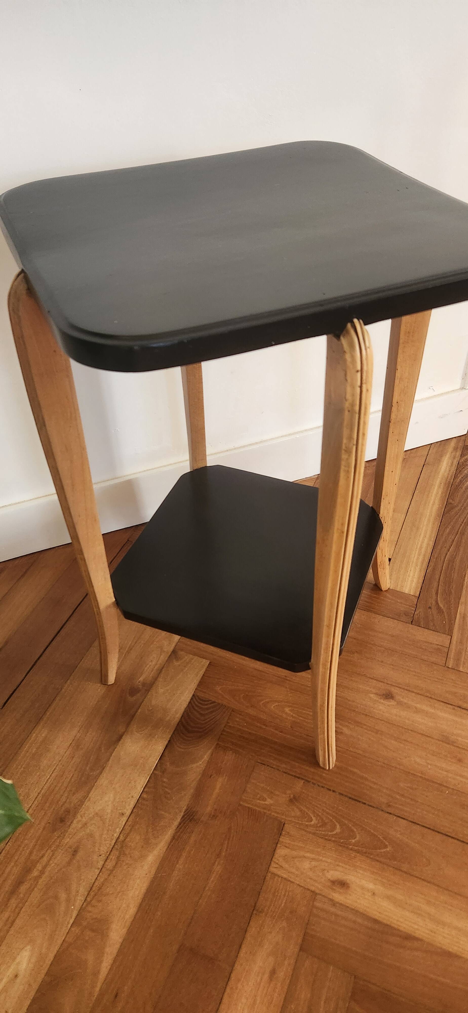 Black lacquered wooden side table with offset tops.