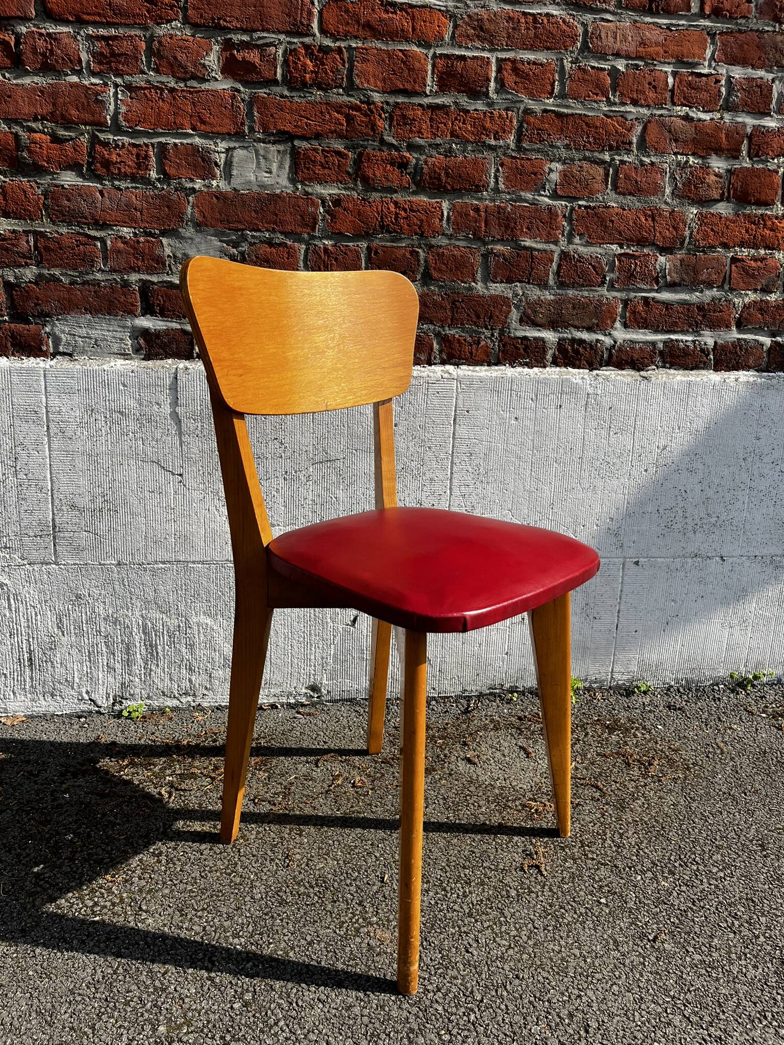 Set of 4 vintage bistro chairs in wood and red faux leather, with splayed legs.