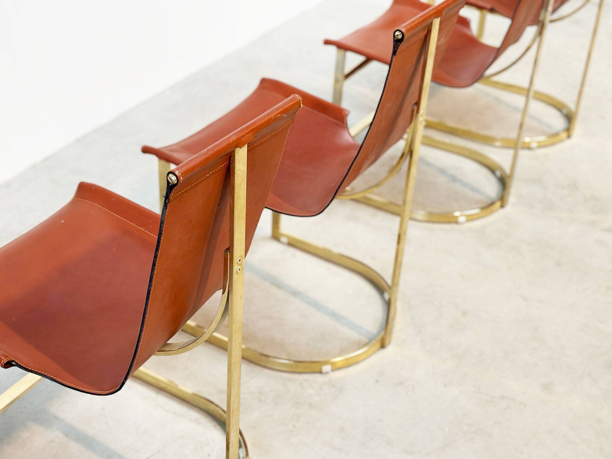 Set of four leather and brass Italian dining chairs