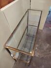 1970s console, minimalist design, burnished brass and glass, Mid-Century style.