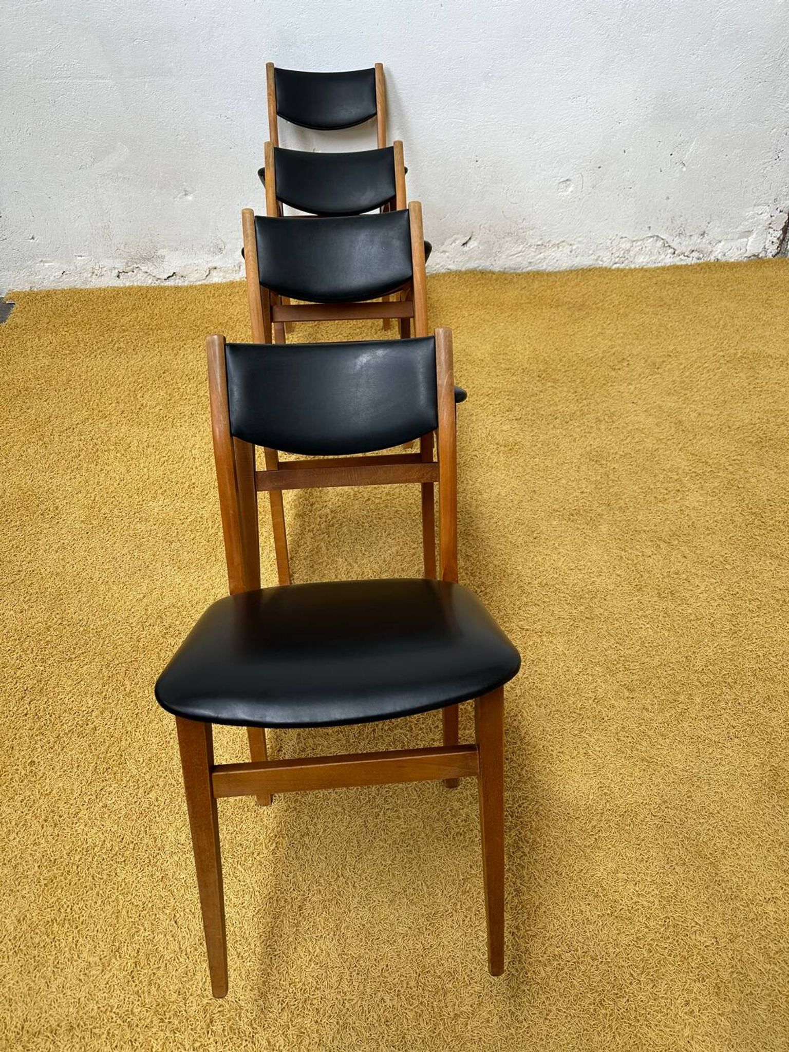 4 Scandinavian chairs in teak and black faux leather.