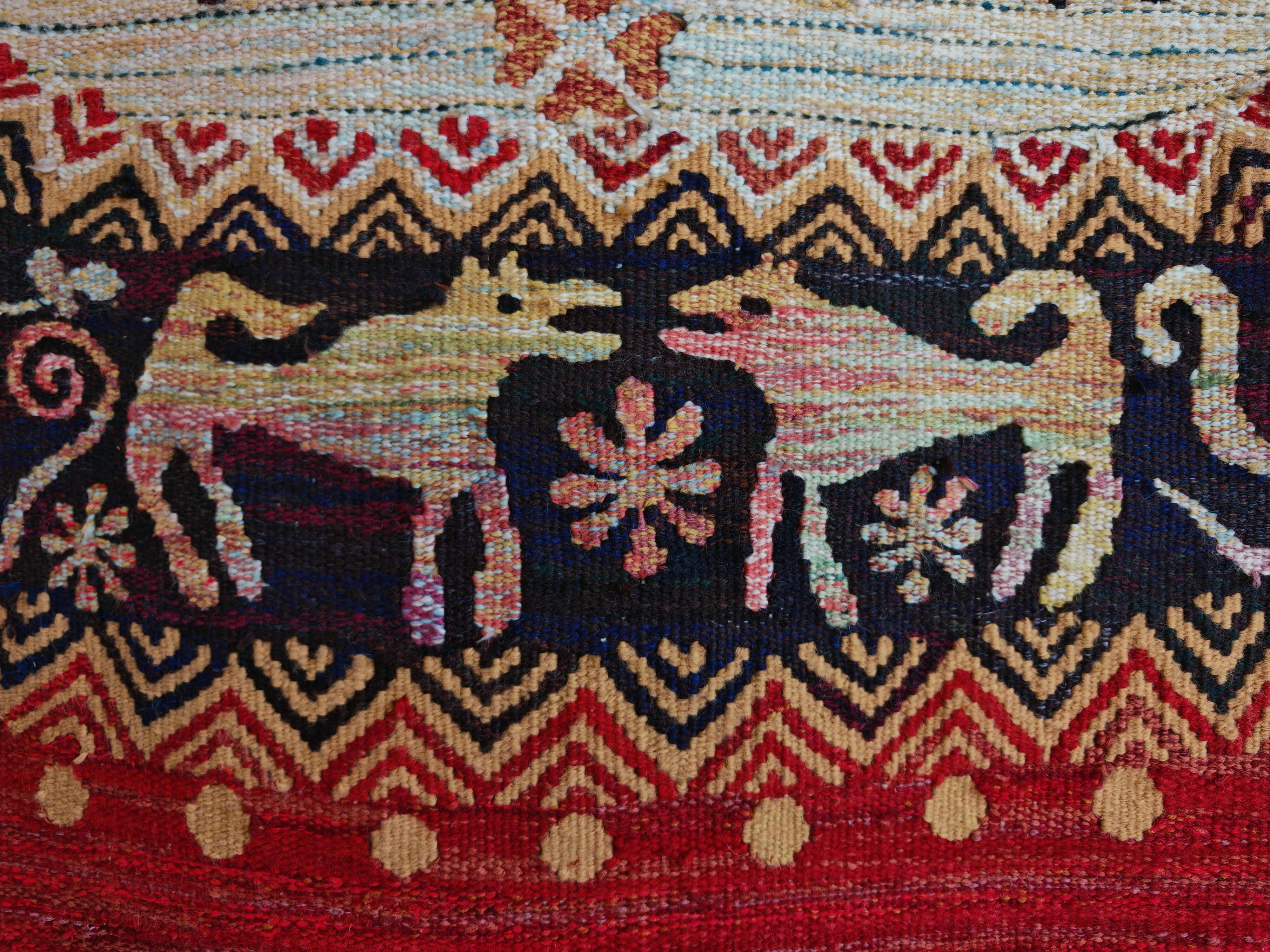 Vintage handwoven tapestry with a folk scene and archaic Slavic writing.