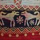 Vintage handwoven tapestry with a folk scene and archaic Slavic writing.