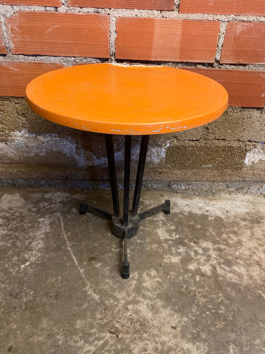 Vintage bistro table with black cast iron base and orange bakelite top, 1950s