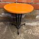 Vintage bistro table with black cast iron base and orange bakelite top, 1950s