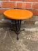 Vintage bistro table with black cast iron base and orange bakelite top, 1950s