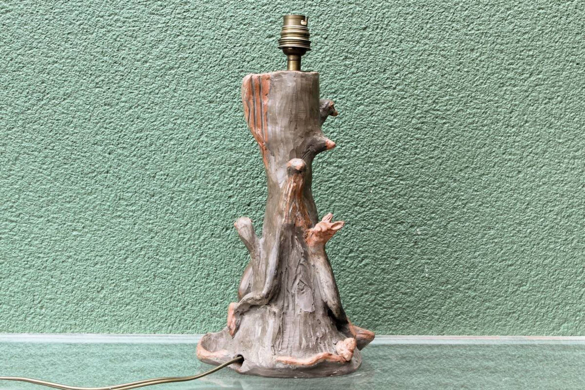 Lamp base in sculpted terracotta featuring birds, signed.