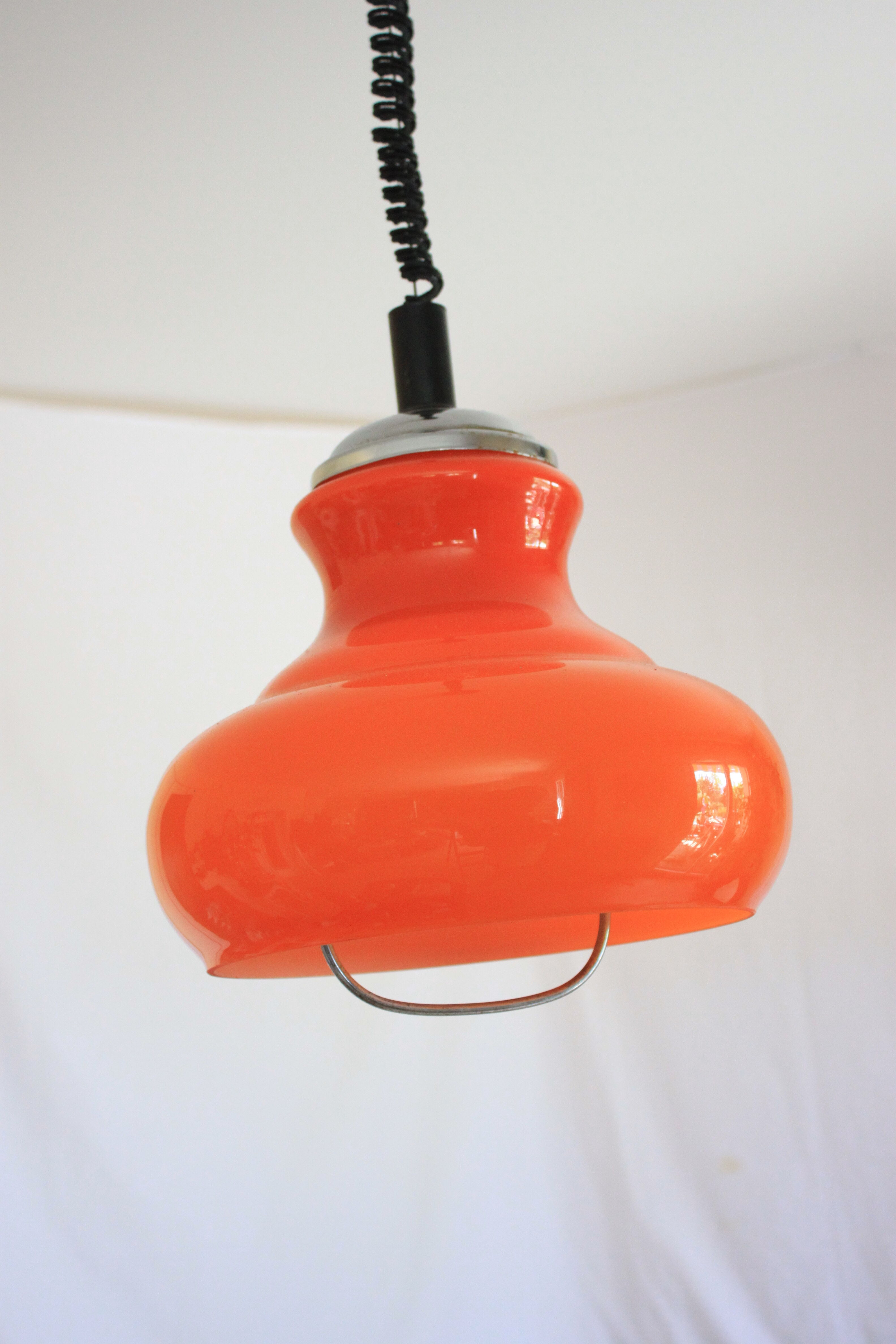 Suspension goes up and down from the kitchen, orange blown glass.