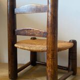 Low brutalist straw chair called fireplace chair