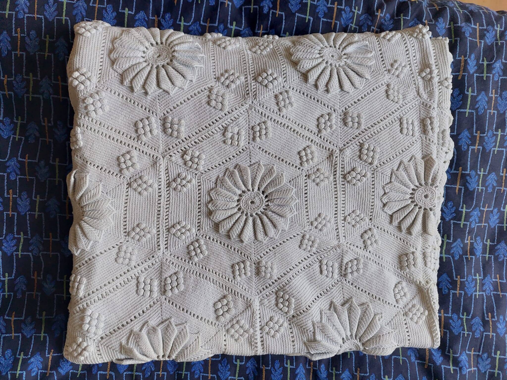 White bed throw with relief embroidery and floral patterns