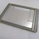 Art Deco mirror in silvered wood, stylised geometric frieze.
