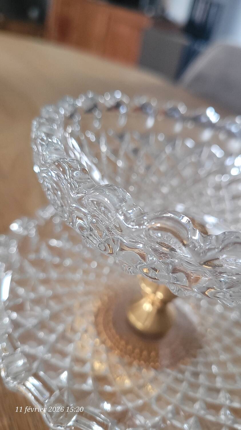 Two-tier display stand in cut glass mounted on a gold metal base.