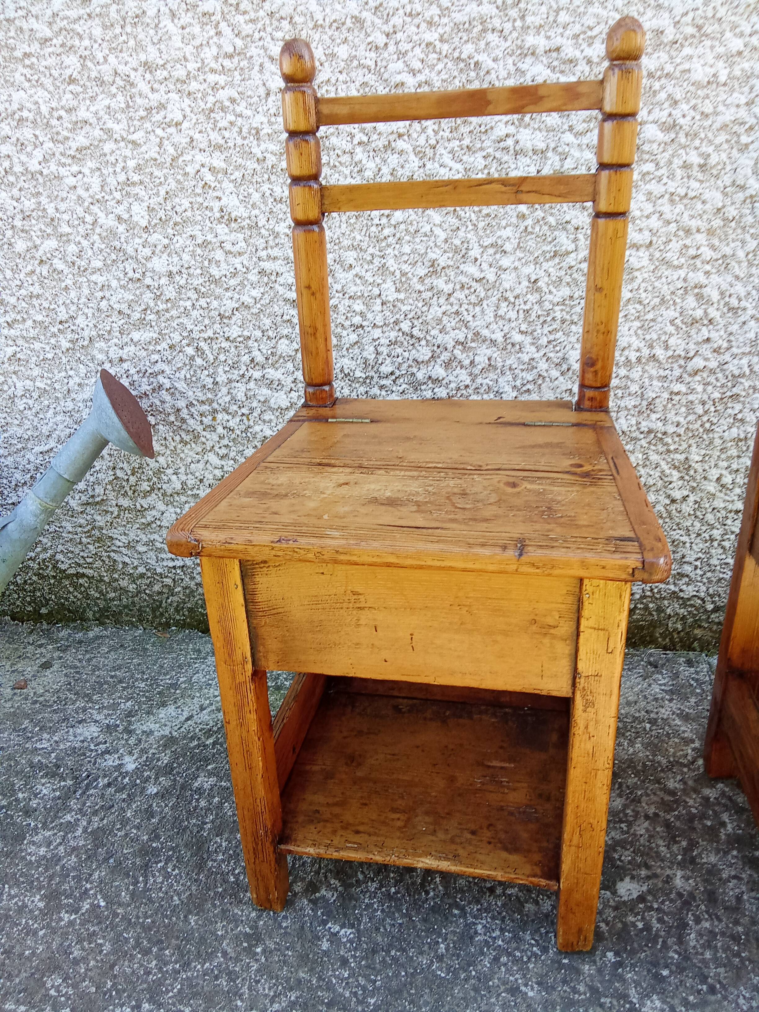 2 old wooden children's chairs with a small chest.