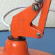 Luxo L9 orange single-arm lamp on plinth
