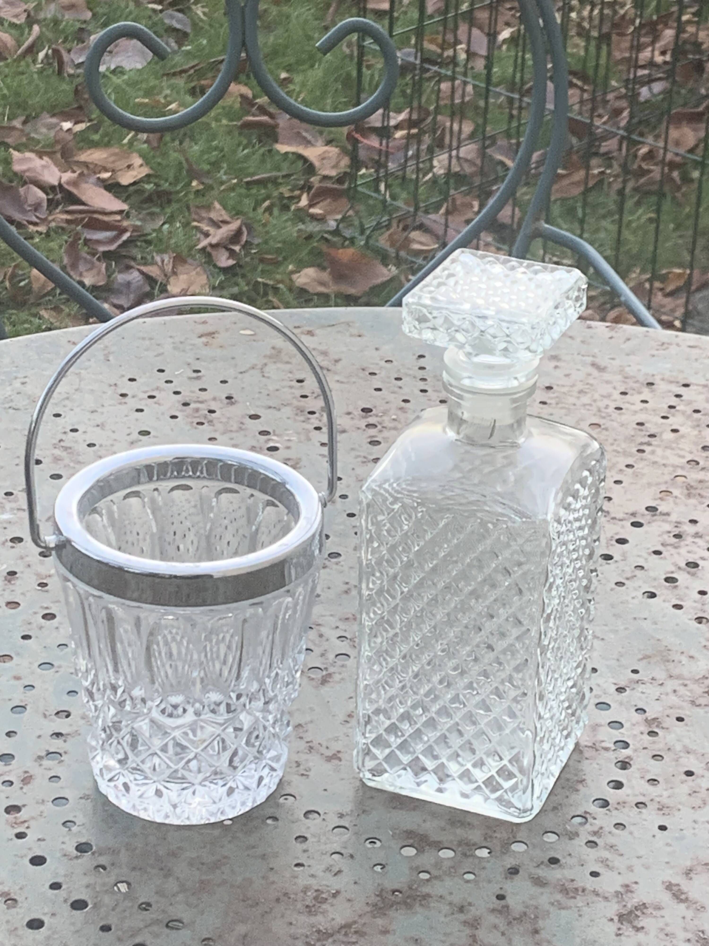 Whiskey carafe and ice bucket in transparent glass and silver-colored metal handle