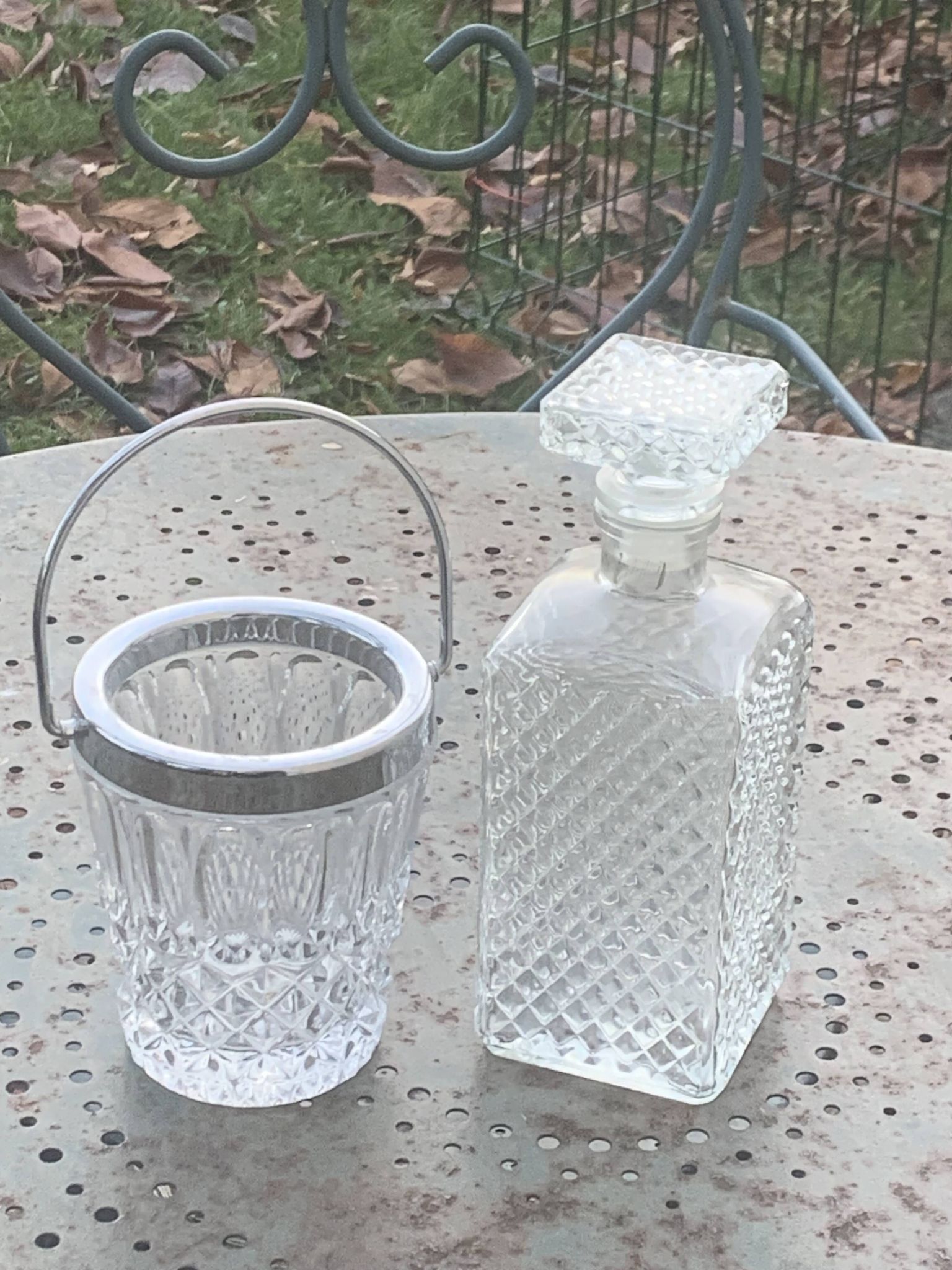Whiskey carafe and ice bucket in transparent glass and silver-colored metal handle